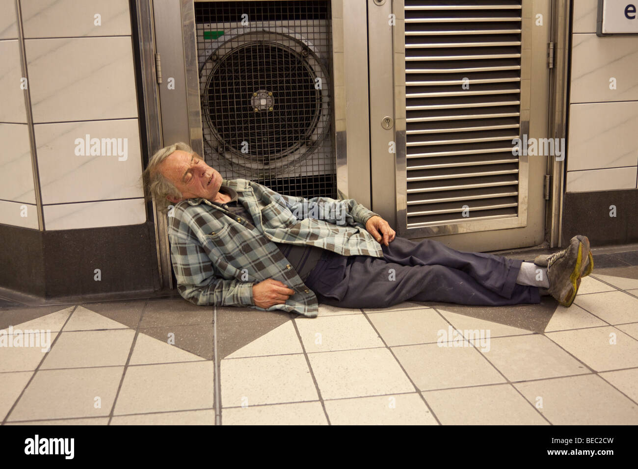 man asleep in London Bank underground station at night Stock Photo