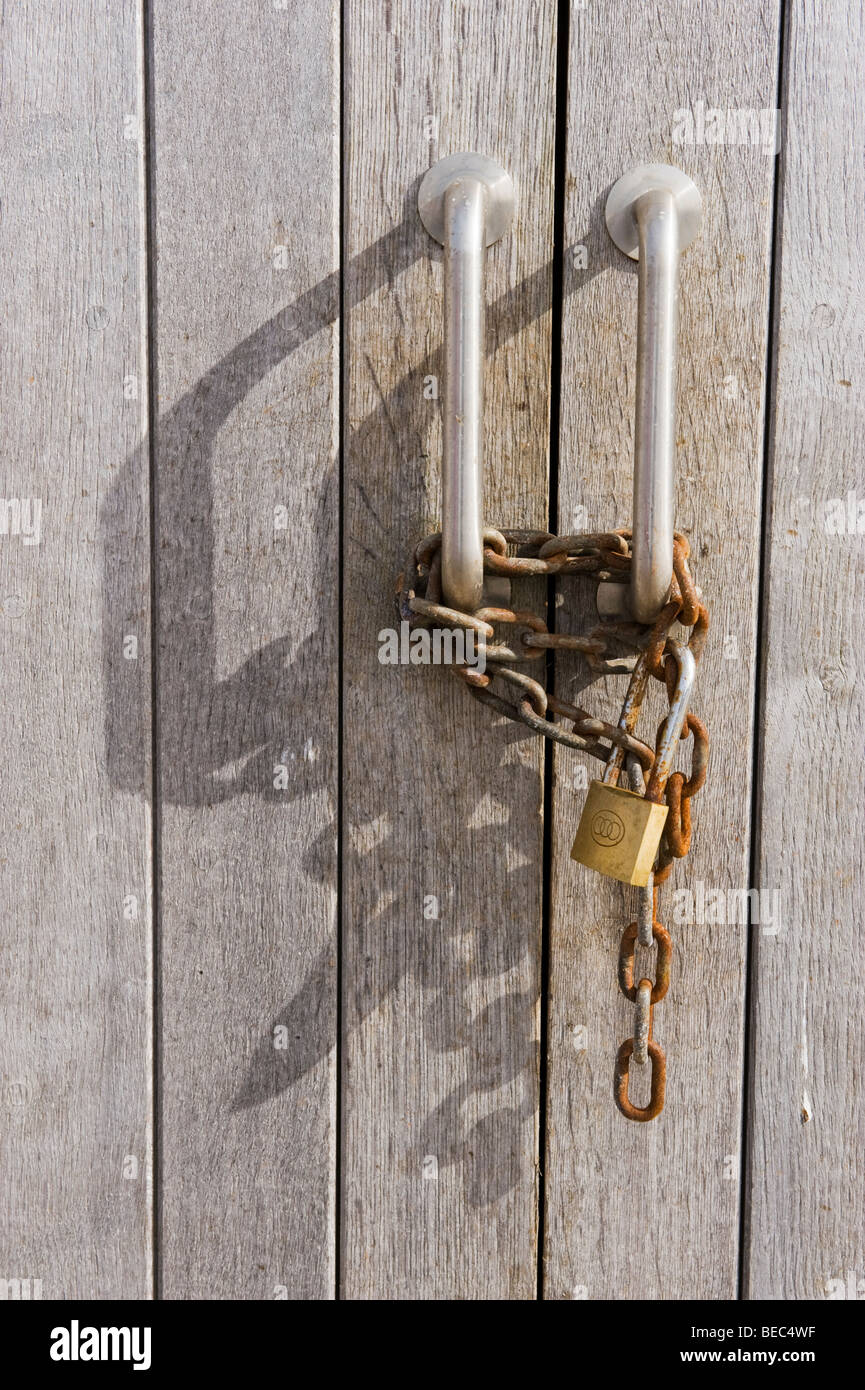Rusty Chain And Padlock On A Pair Of Wooden Shed Door Handles In
