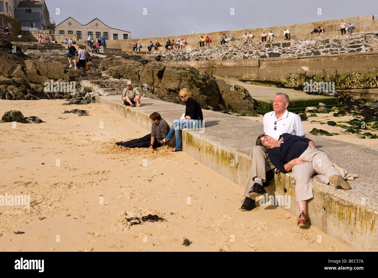 Tourists visitors and people relaxing and sunbathing on the beach at St Ives, Cornwall, UK Stock Photo