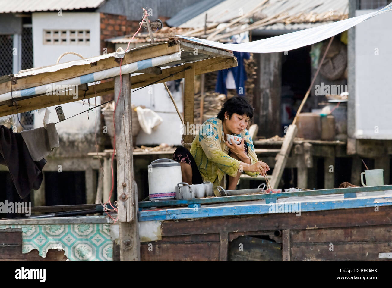 A woman eating on a houseboat on the Mekong Delta, Vietnam Stock Photo