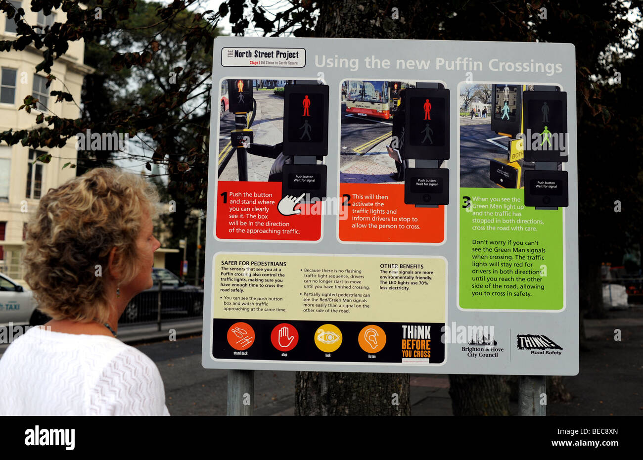 A woman reads the instructions how to use one of the new style Puffin Crossings in Brighton city centre Stock Photo