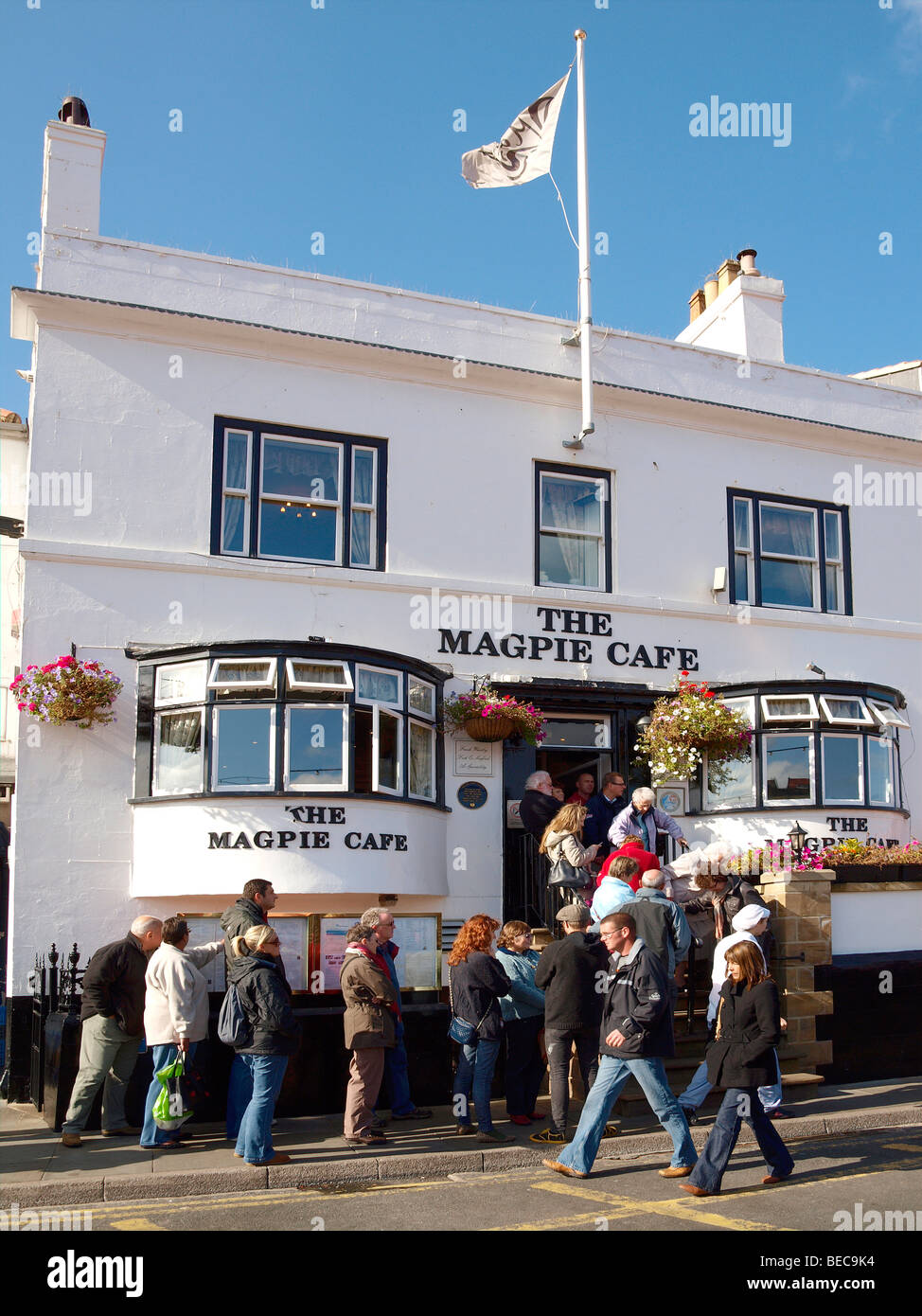 A queue on the steps waiting for fish and chips at the famous Magpie Café in Whitby North Yorkshire Stock Photo