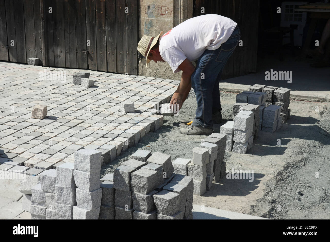 Man building a street with cubic paving stones, Larnaca, Cyprus. Stock Photo