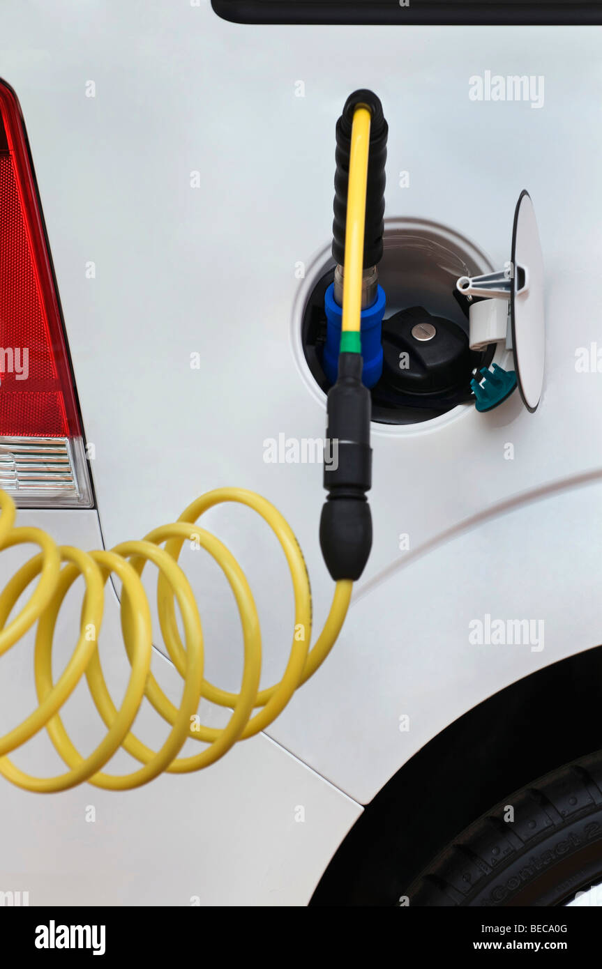 Refueling gas with a nozzle and hose on a car, besides the normal tank cap Stock Photo
