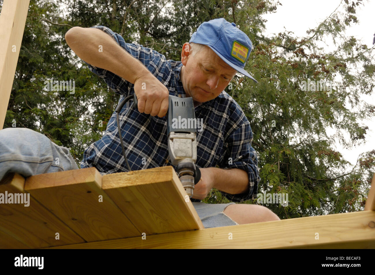 Man drilling holes into a wooden beam Stock Photo Alamy