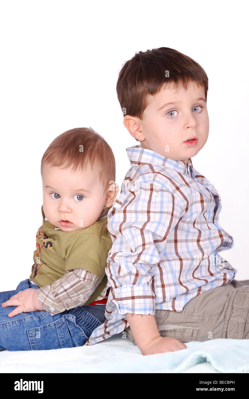 Two boys -baby and child - brothers, portrait on the white background Stock Photo