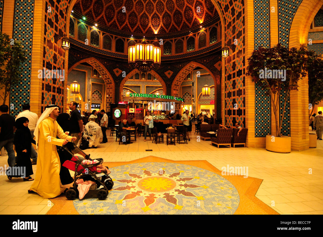 Shopping tourists in front of an elaborately decorated arch in the Persian part of the Ibn Battuta Mall, Dubai, United Arab Emi Stock Photo