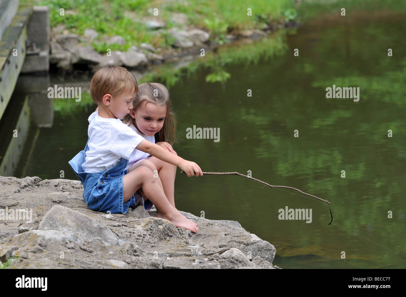 Boy playing with fishing pole hi-res stock photography and images