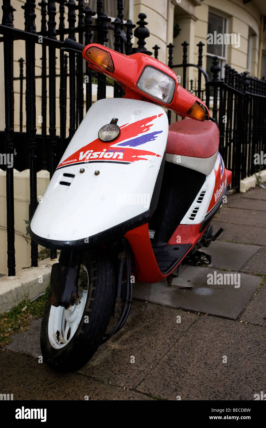 Old vintage white and Honda Vision scooter chained up in street to railings in Hove, West Sussex, UK Stock Photo - Alamy