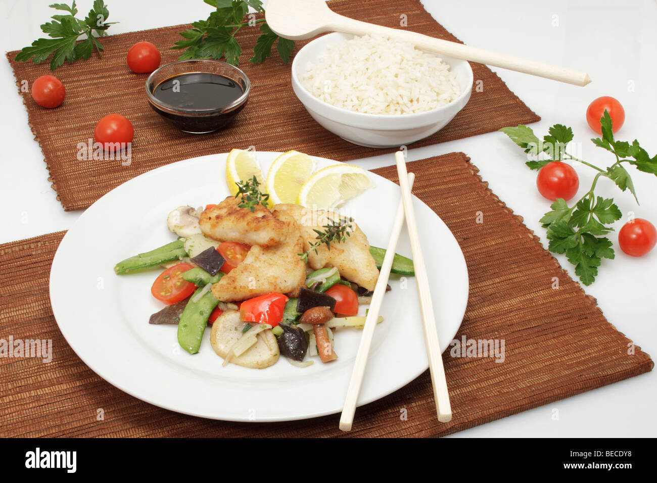Pangasius filet on a bed of Asian vegetables with sweet soy sauce and rice Stock Photo