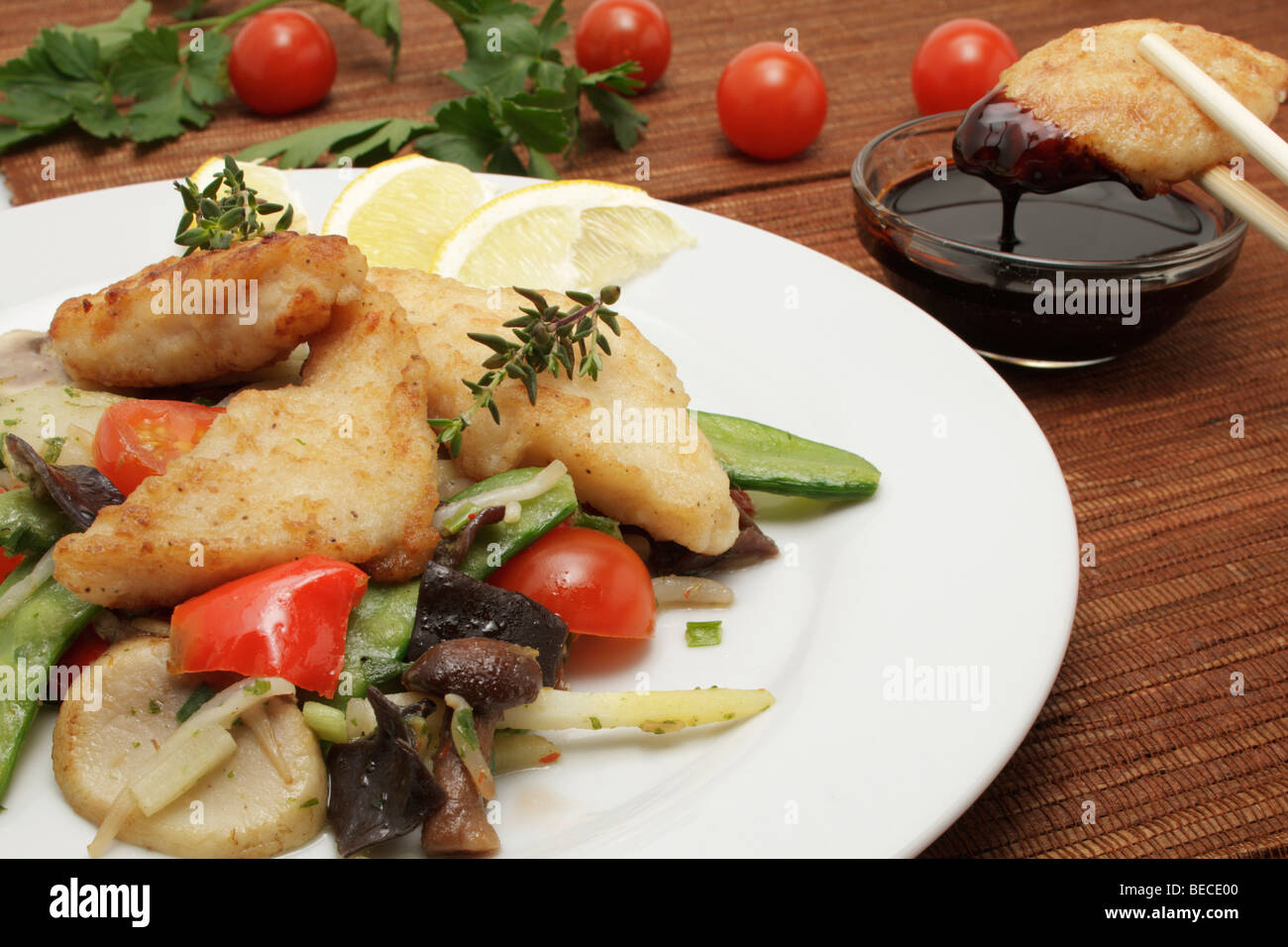 Pangasius filet on a bed of Asian vegetables with sweet soy sauce Stock Photo