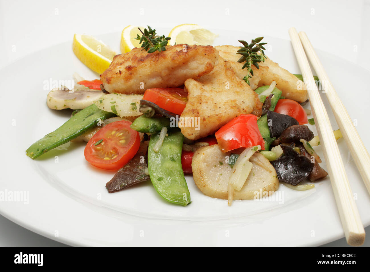 Pangasius filet on a bed of Asian vegetables Stock Photo