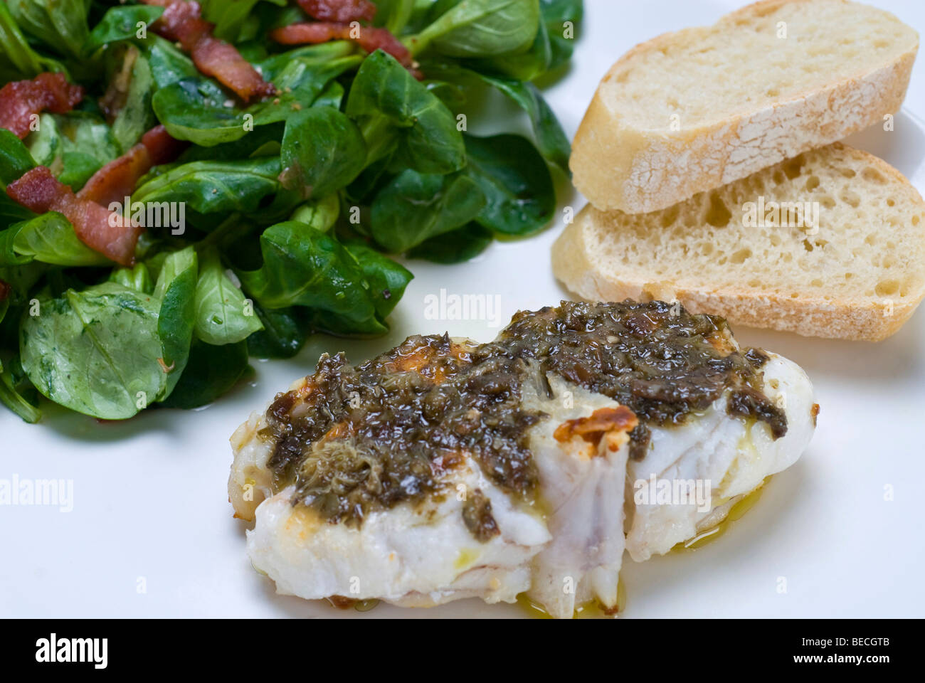 Sea-Devil fish (Lophius piscatorius) with with algae tartar and field salad (Valerianella locusta) with roasted bacon strips an Stock Photo