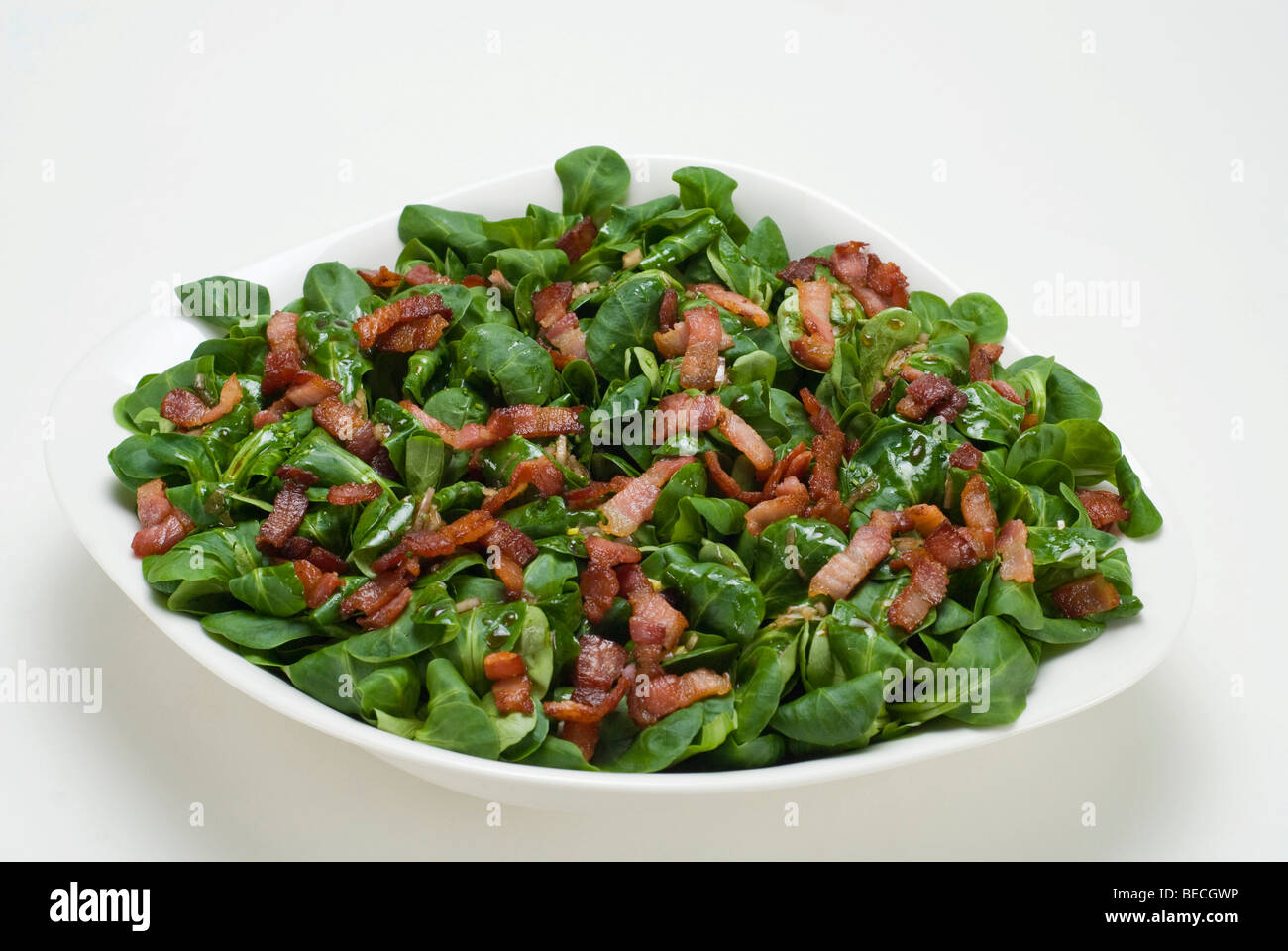Field salad (Valerianella locusta) with roasted bacon strips Stock Photo