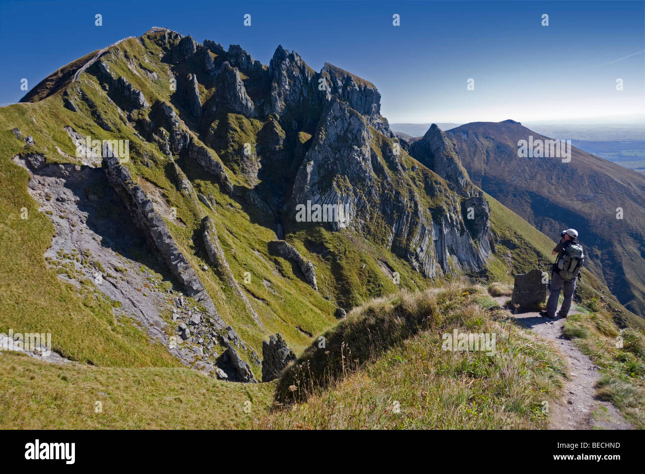 A hiker photographing the 'Puy de Sancy' top. Randonneur photographiant le sommet du Puy de Sancy. Stock Photo