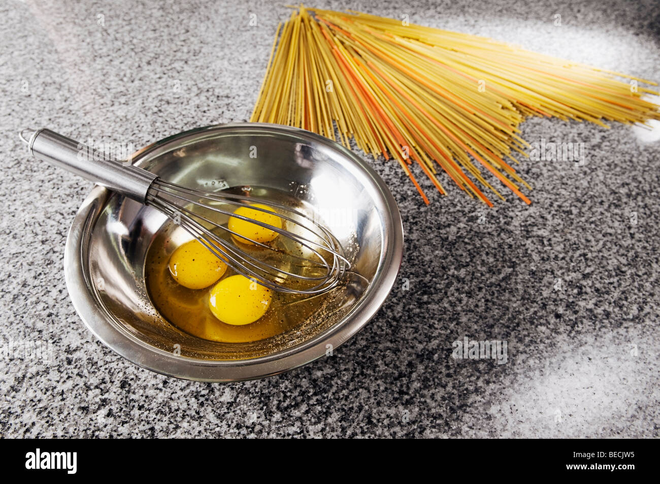 Egg yolk and an egg beater in a bowl with spaghetti Stock Photo Alamy