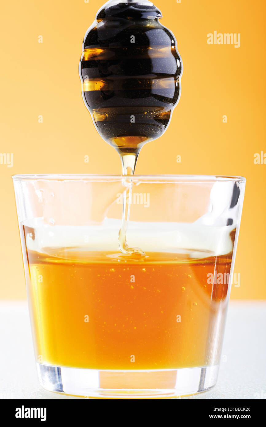 Glass jar with honey with honey dipper Stock Photo Alamy