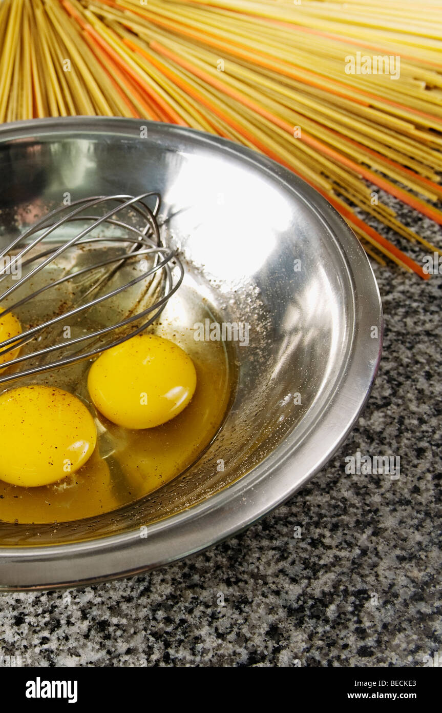 Egg yolk and an egg beater in a bowl with spaghetti Stock Photo Alamy