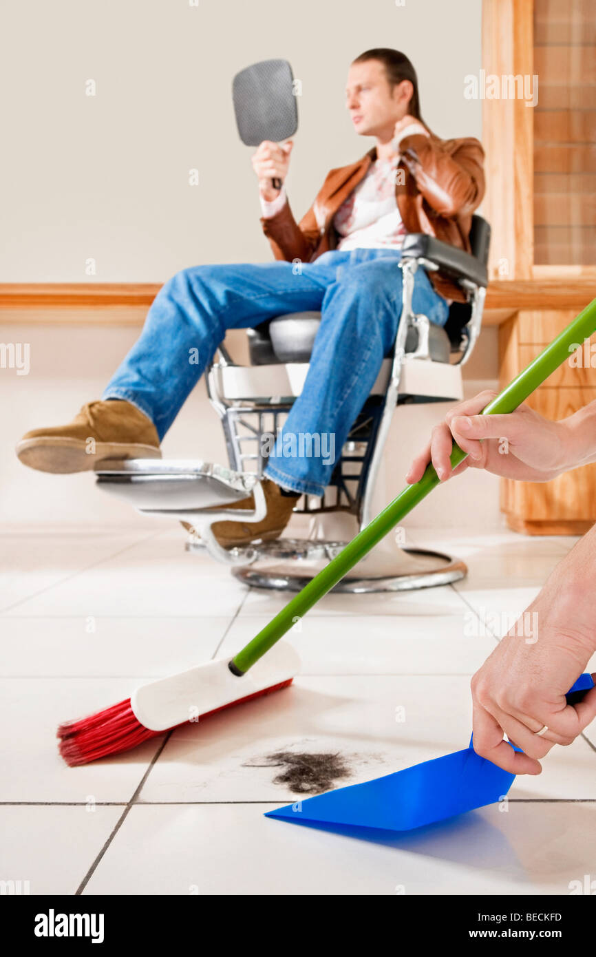 Barber cleaning floor hairdresser salon hires stock photography and