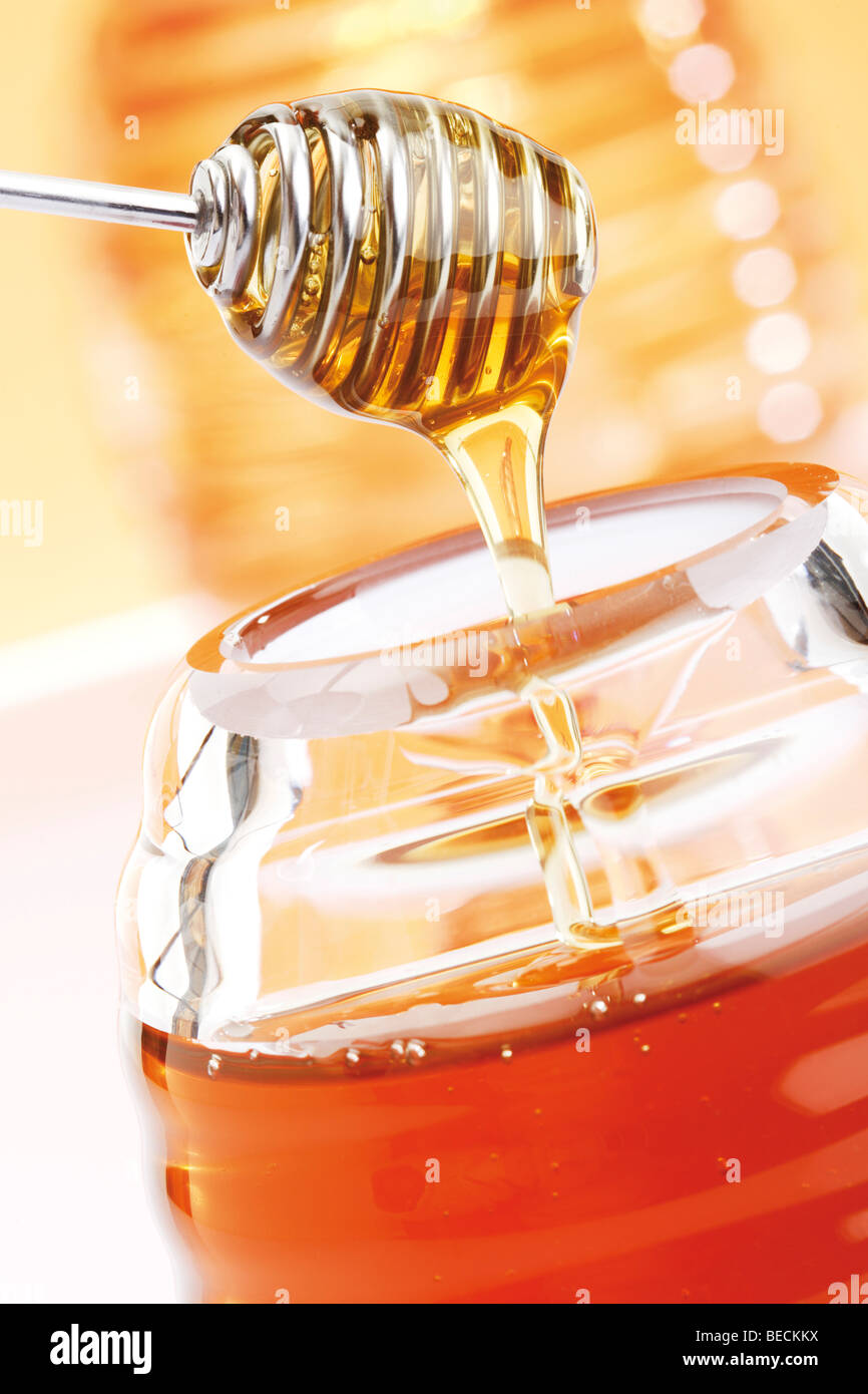 Glass jar with honey with honey dipper Stock Photo Alamy