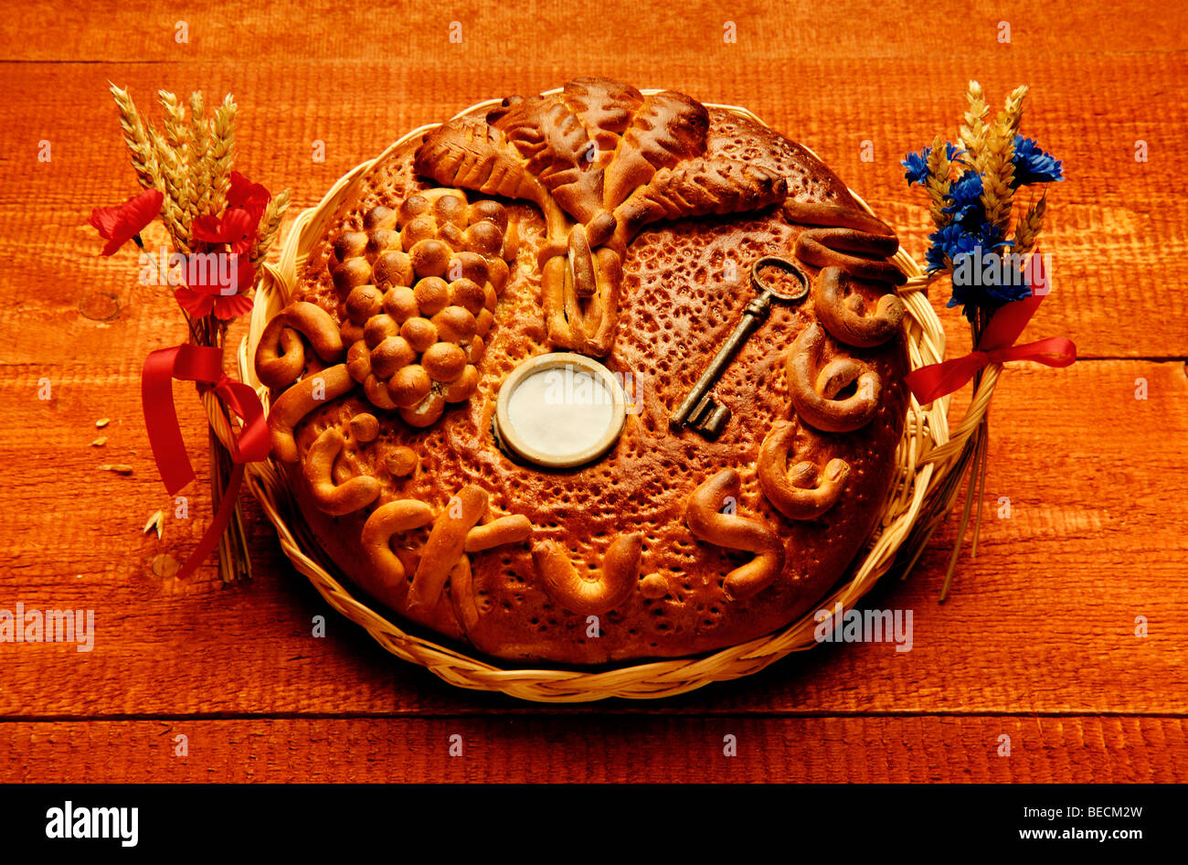 Decorated loaf of bread with baked-in key and salt cellar in a basket as a housewarming gift Stock Photo