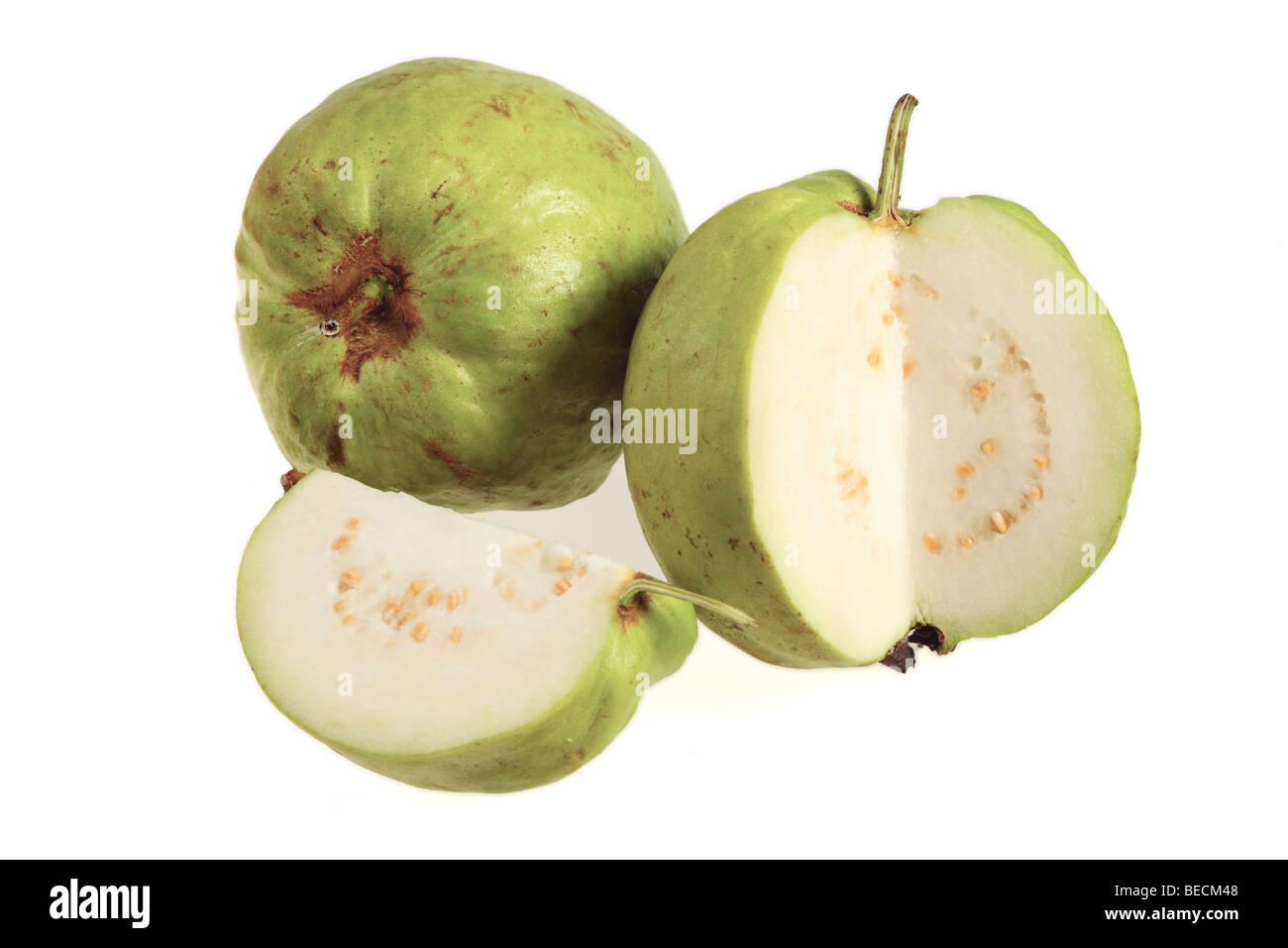 Two apple guava fruits, one of them cut open, on a white background. Stock Photo