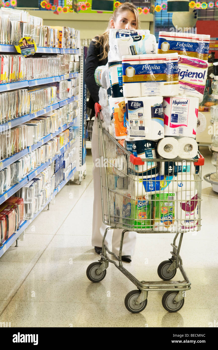 Woman pushing shopping cart loaded with toilet rolls Stock Photo Alamy