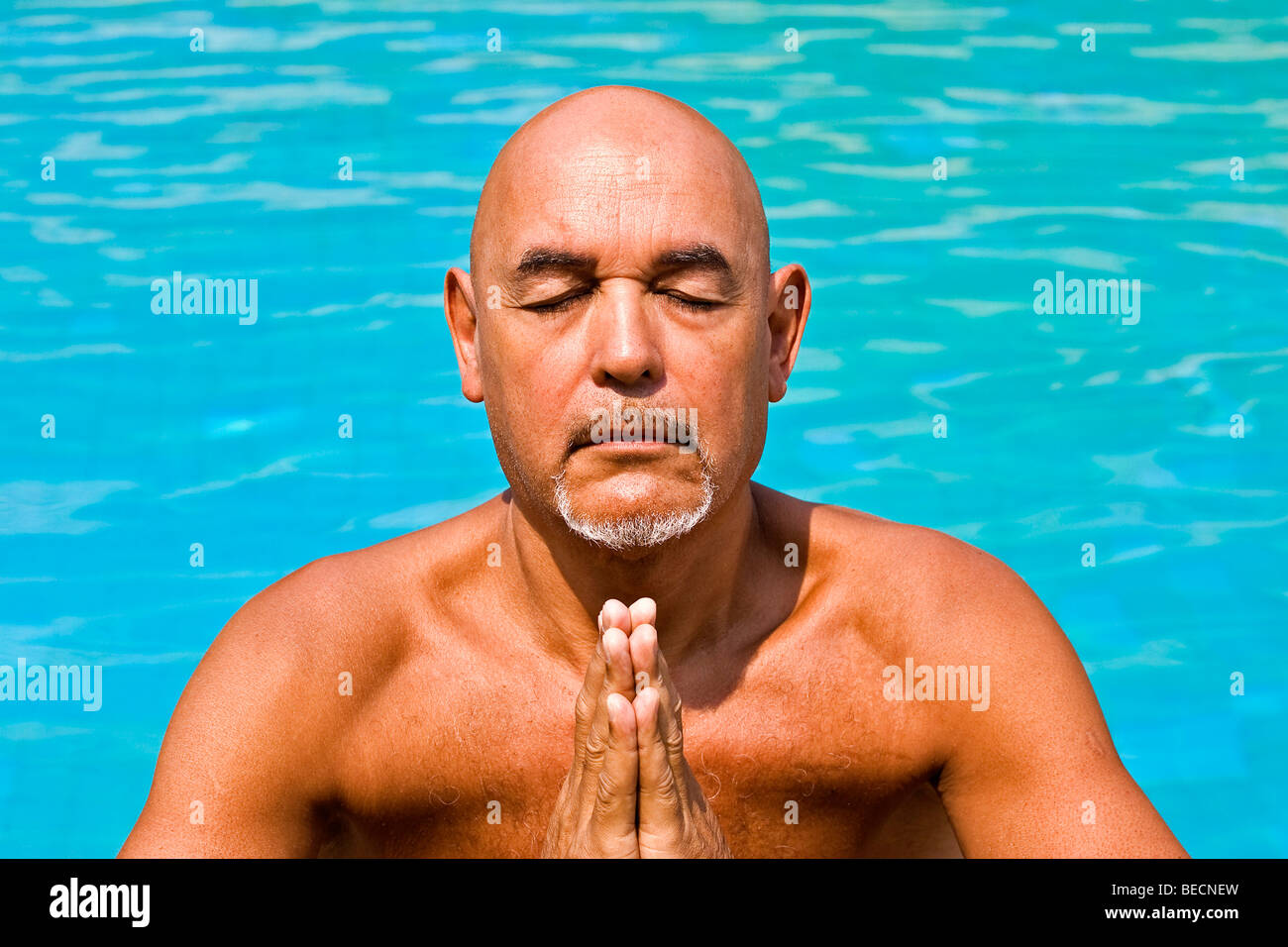 Bald elderly gentleman meditating in water Stock Photo