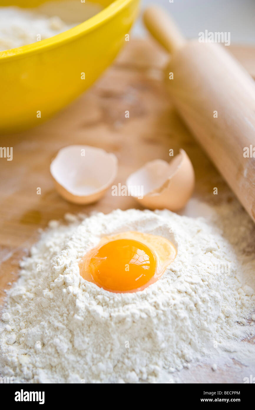 Baking utensils, flour, egg, rolling pin and a mixing bowl Stock Photo