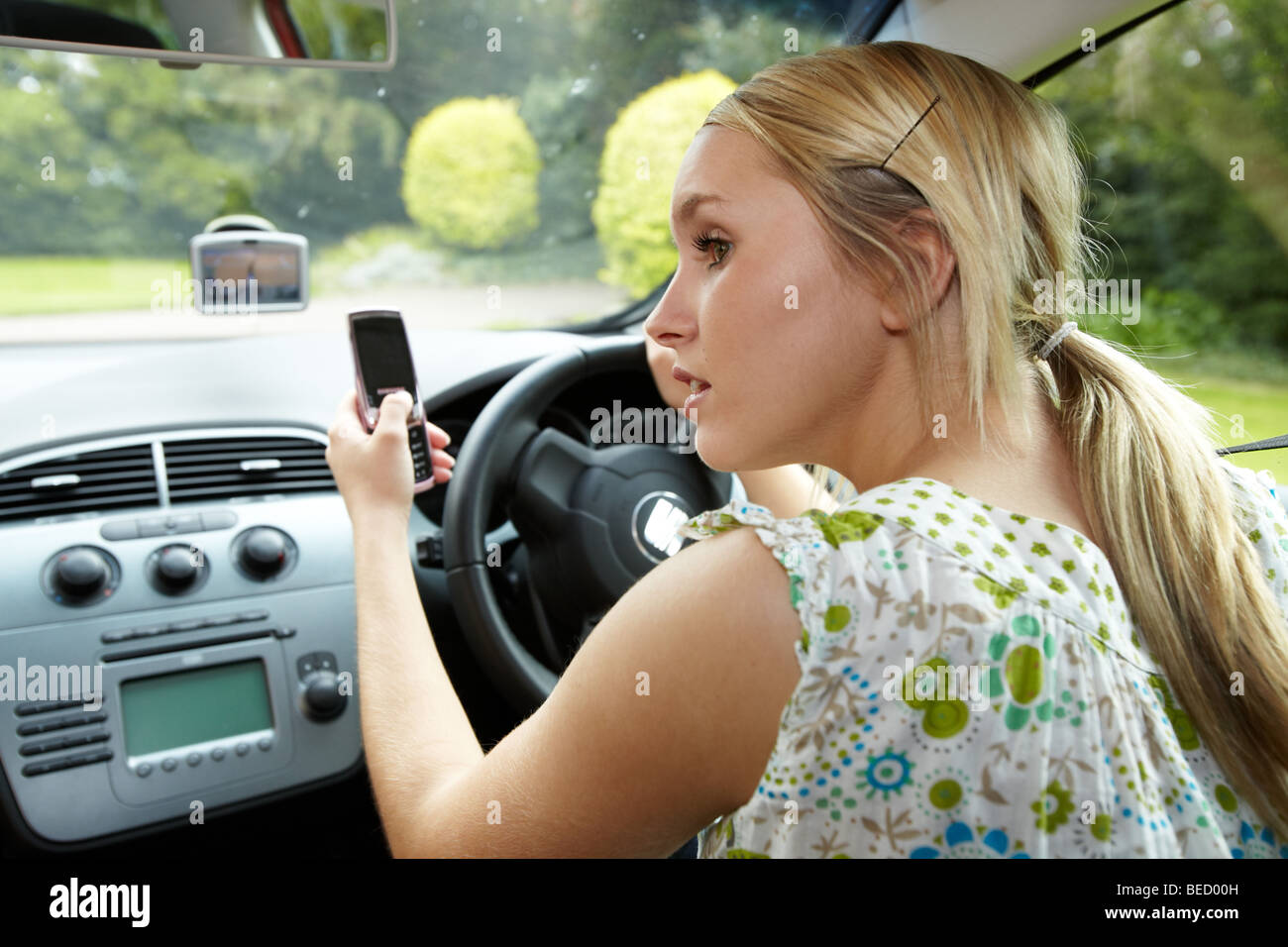 Girl driving car using phone Stock Photo