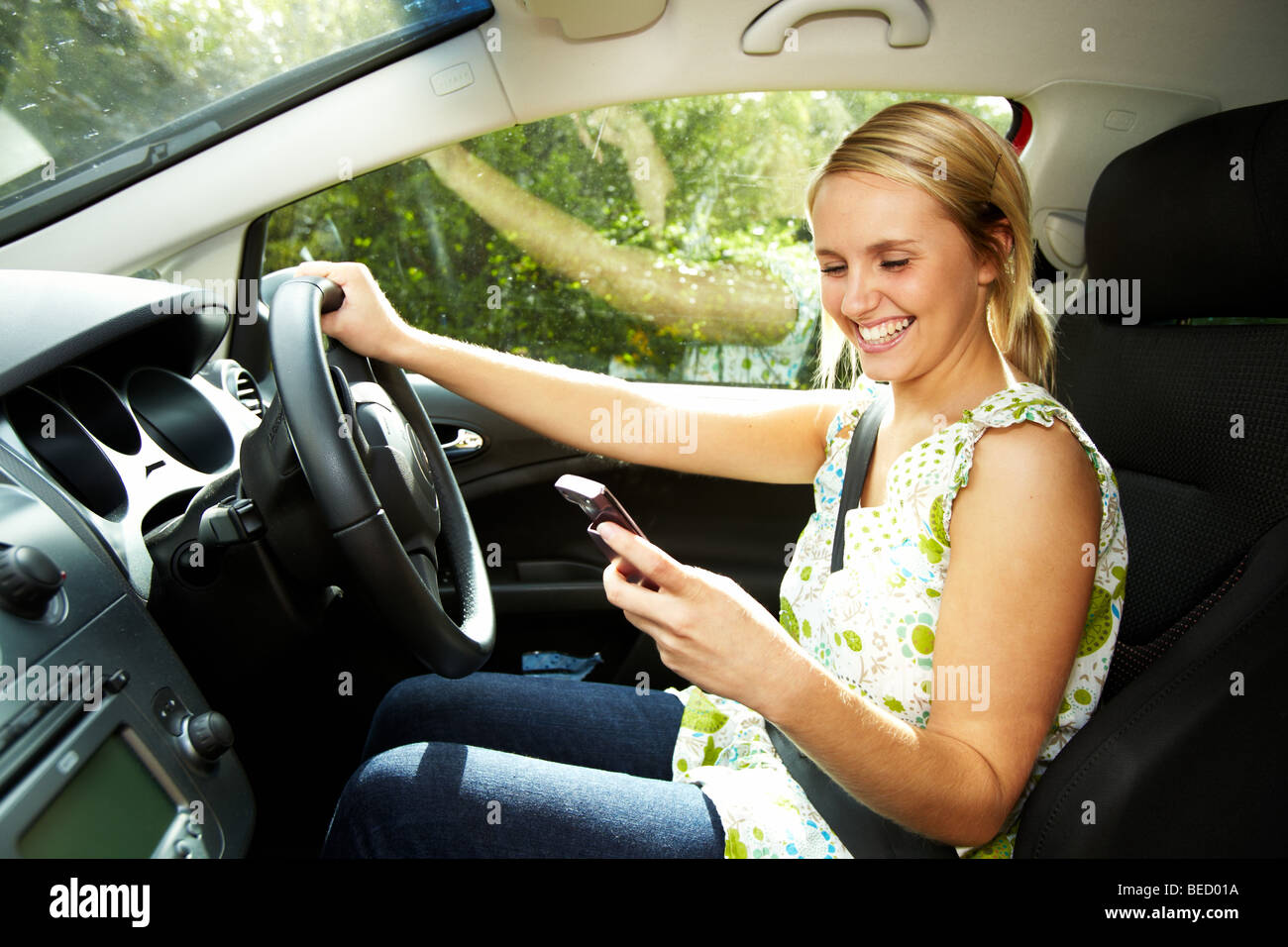 Girl driving car using phone Stock Photo
