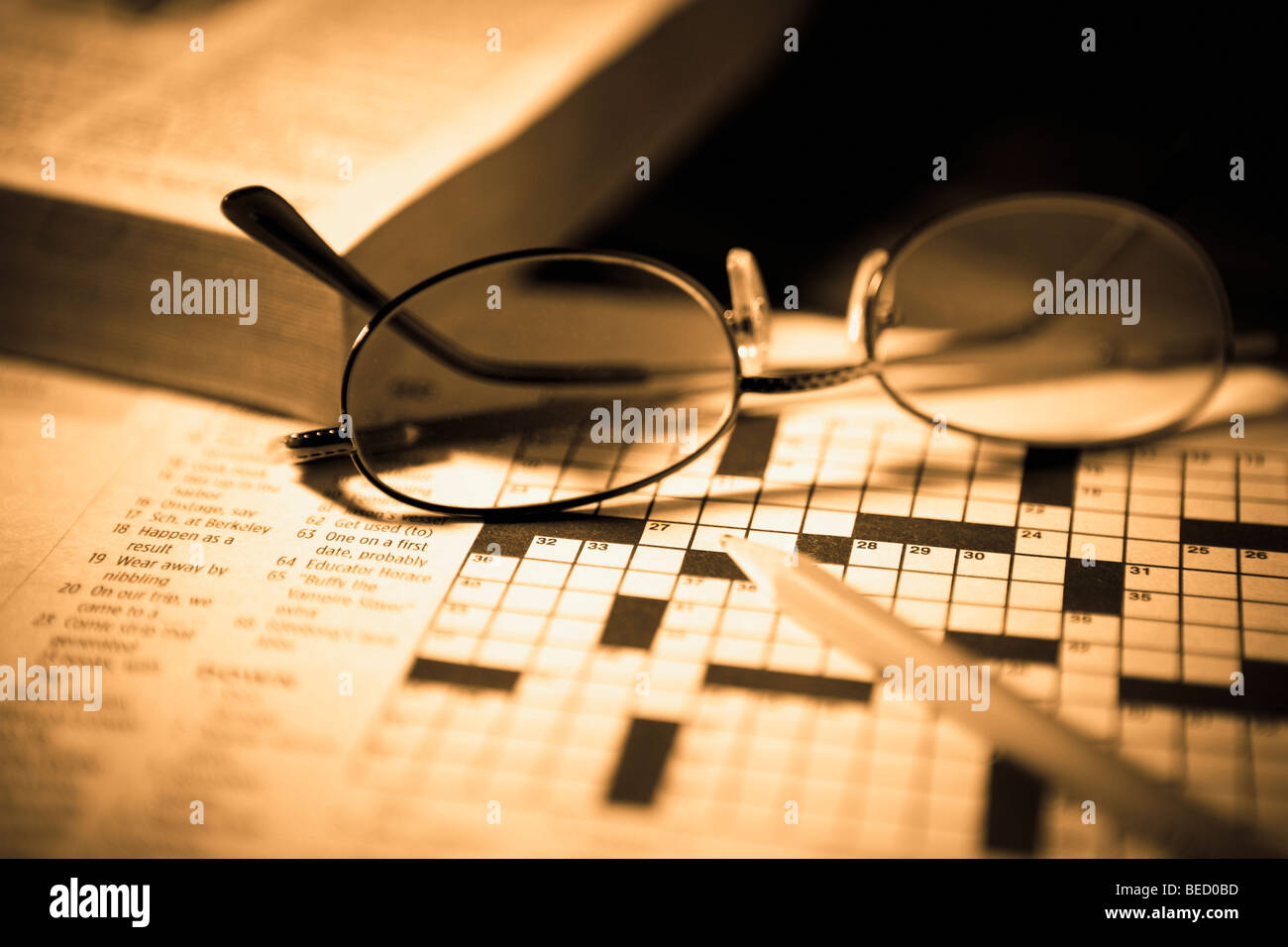 Closeup of a pencil and eyeglasses on a crossword puzzle Stock Photo