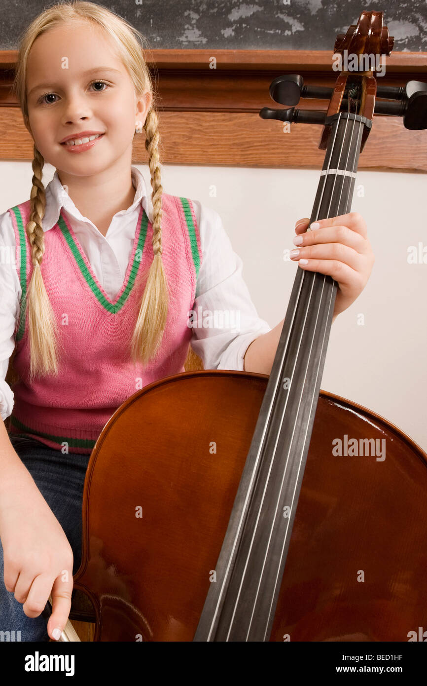 Schoolgirl playing a violin in a classroom Stock Photo