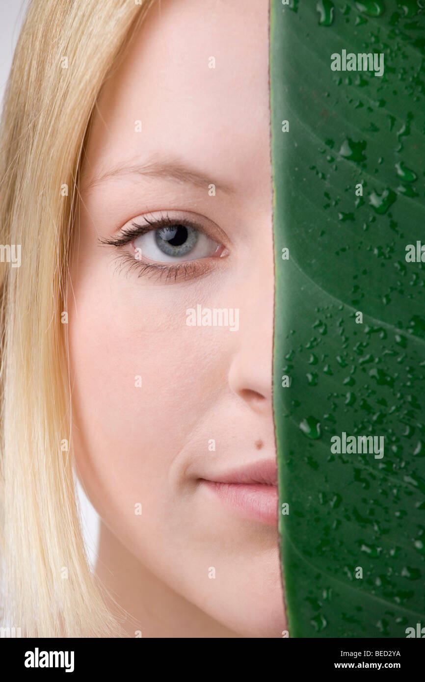Young woman next to a leaf, moisture and sensitive skin Stock Photo