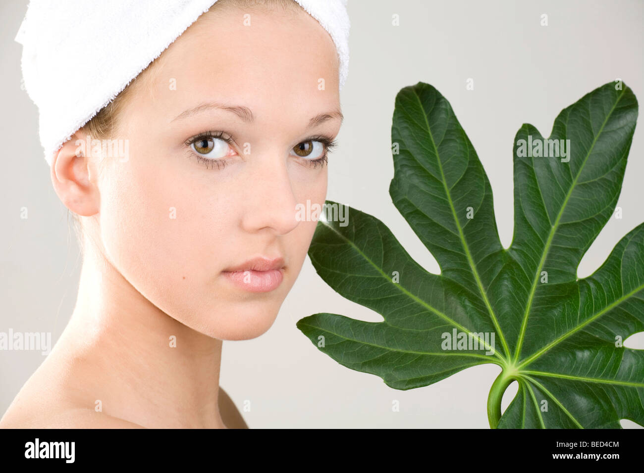 Young woman, towel wrapped around her head, herbal skin care Stock Photo