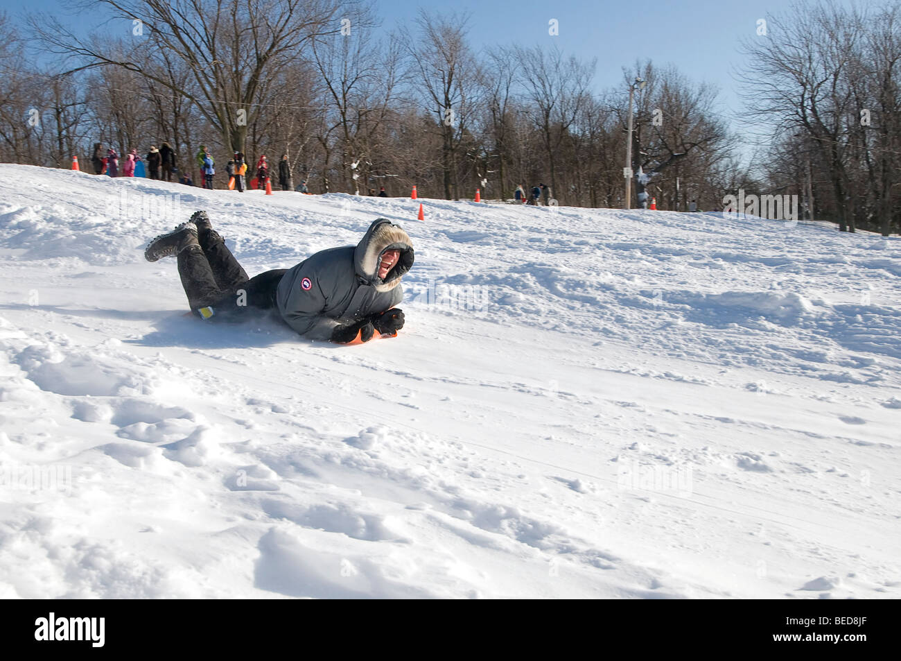 men sliding down hill in the snow Stock Photo Alamy