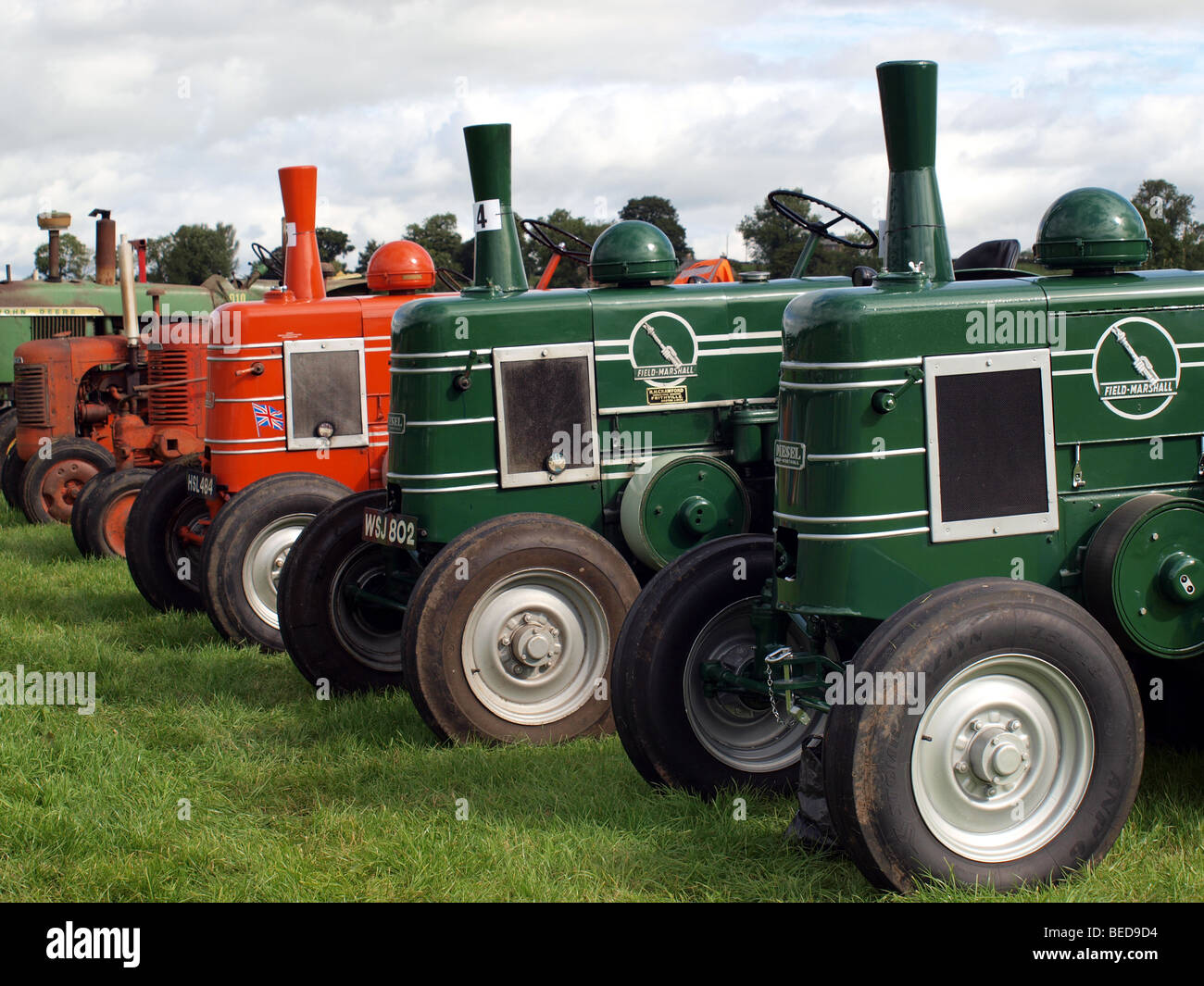 lineup of orange and green vintage tractors at local agricultural show