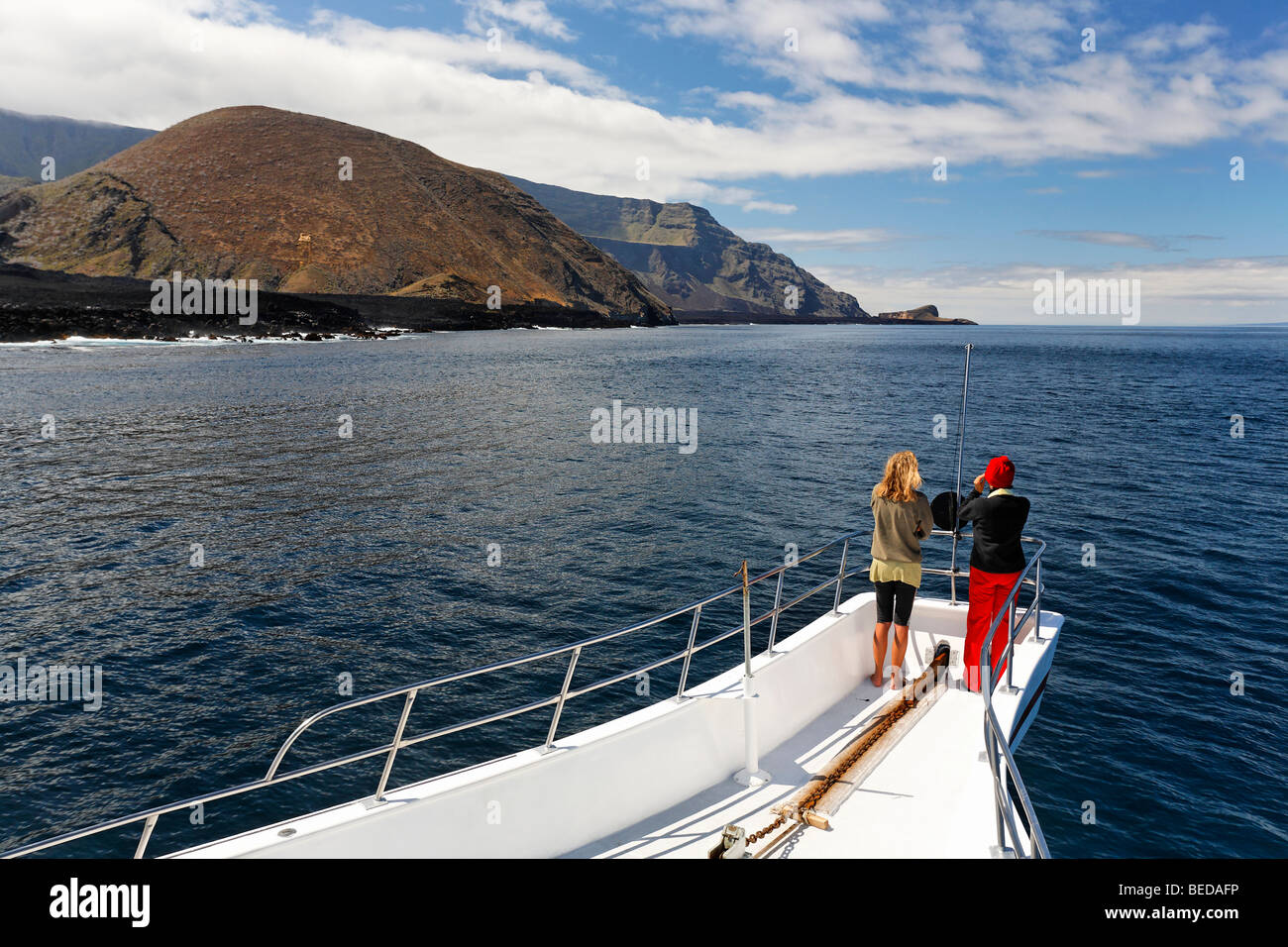 Two woman standing on the bow of the ship, Reina Silvia, volcanic mountains, northern tip of Ponta de Sao Vicente, Isabella Isl Stock Photo