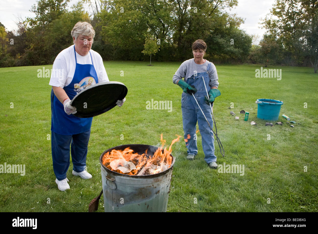 Fanning flames in oxidation barrels during Raku process, USA Stock ...