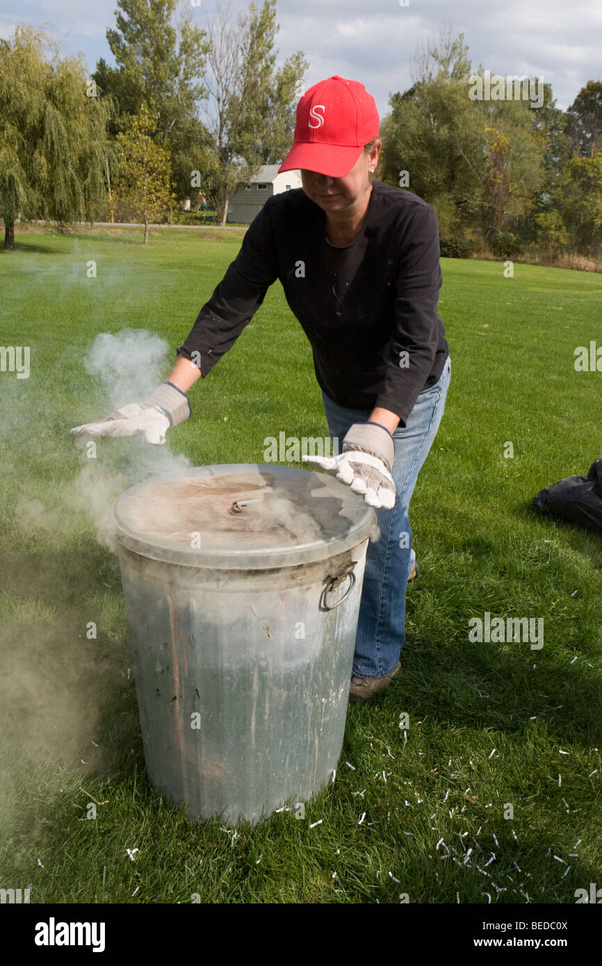 Potter placing lid on oxidation barrel during Raku process, USA Stock ...