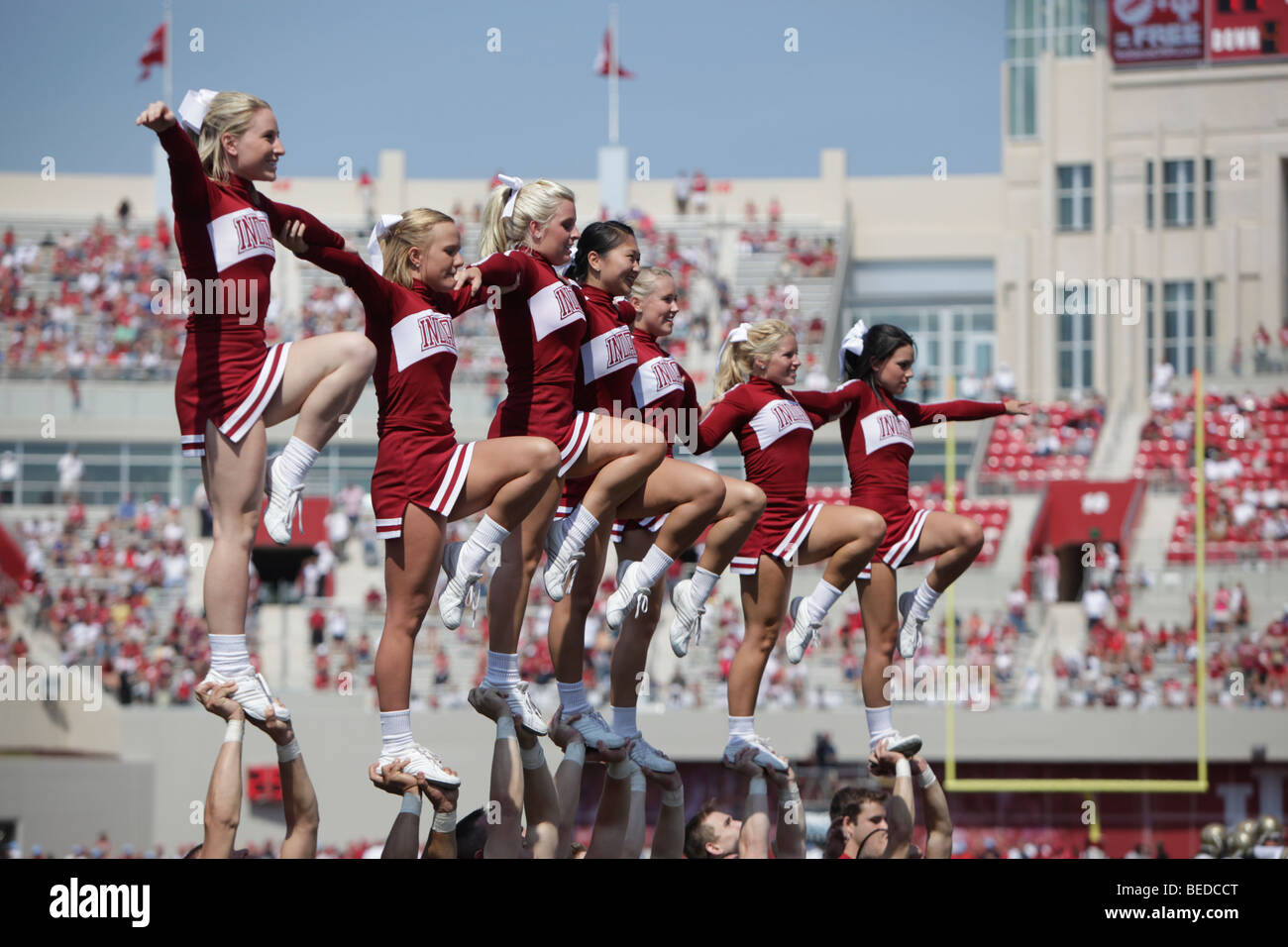 IU cheerleaders during an Indiana University football game with the new stadium construction in the background. Stock Photo