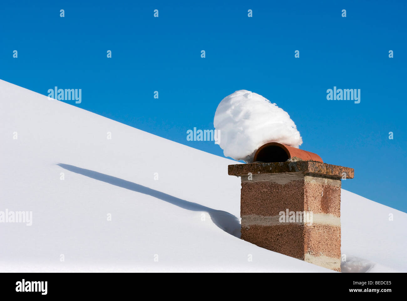 Snow on a brick chimney under a blue sky, Graubuenden, Switzerland, Europe Stock Photo