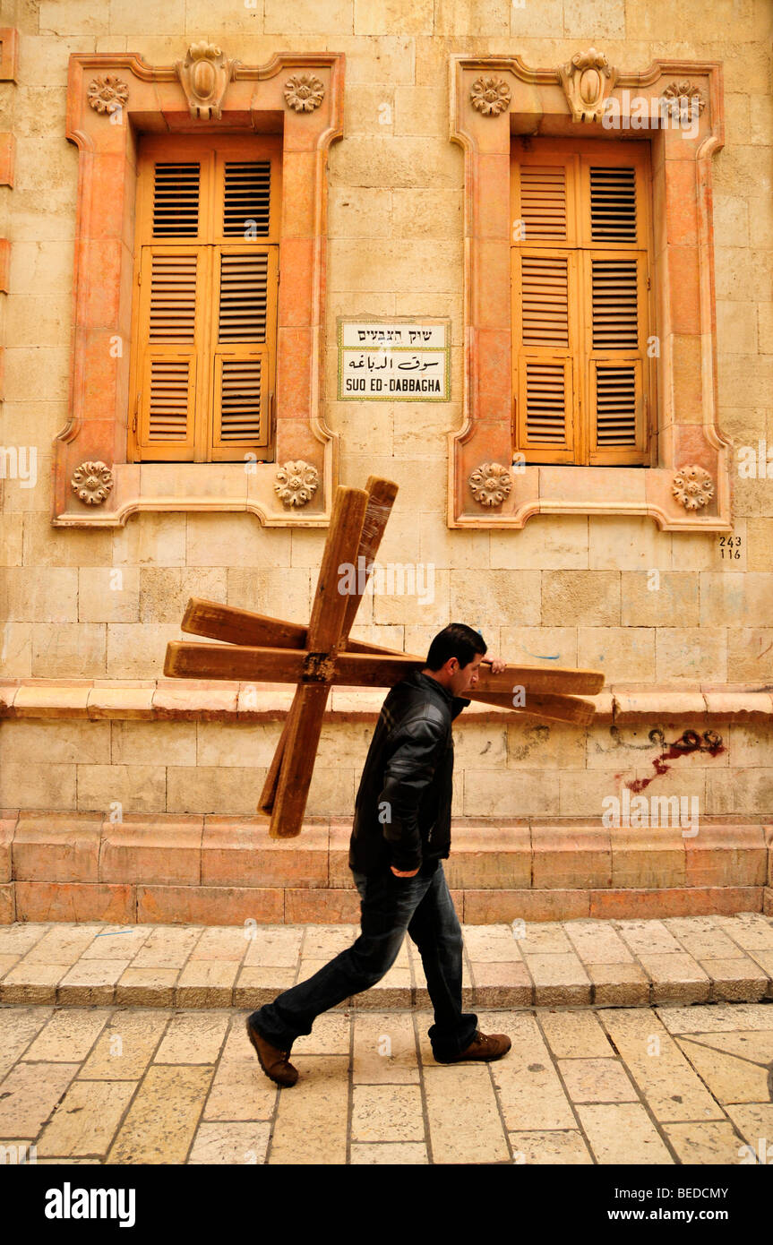 Young Palestinian carrying rental crosses for pilgrims through the Via Dolorosa, Jerusalem, Israel, the Near East, Orient Stock Photo