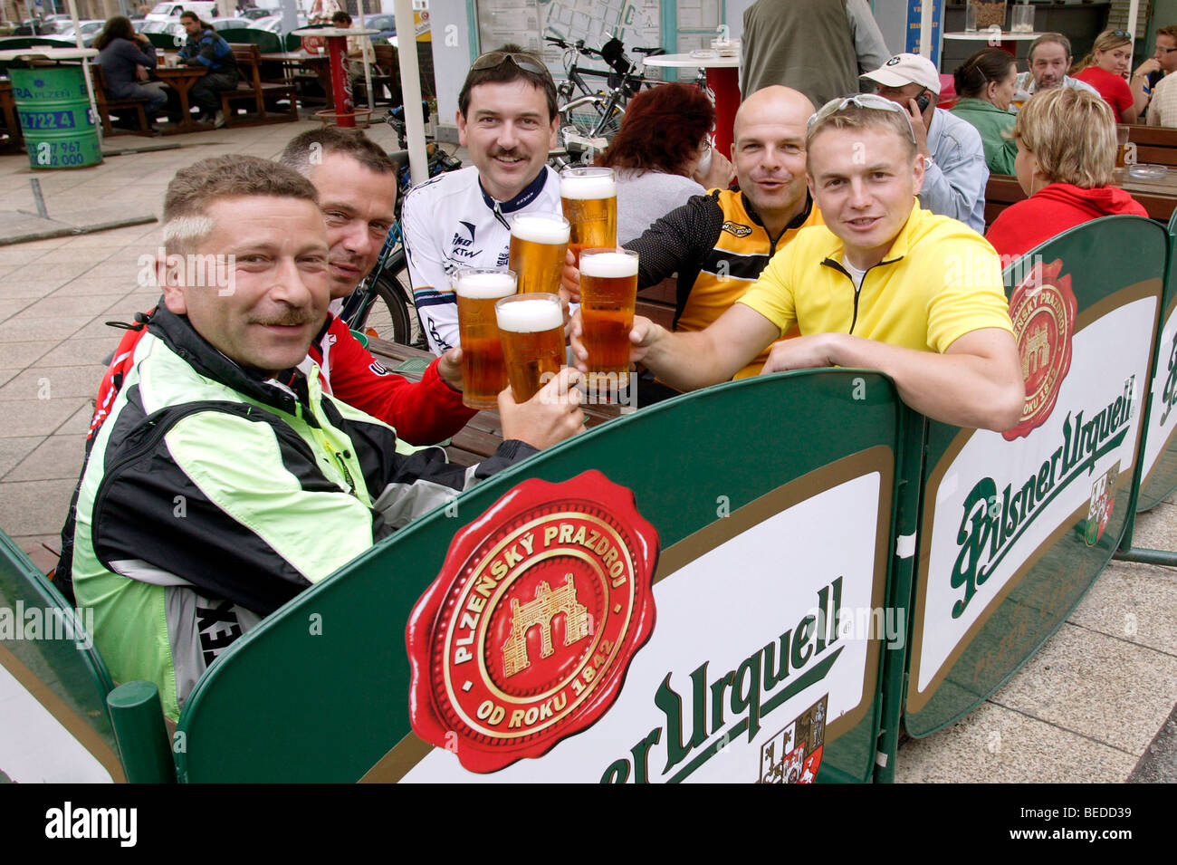 Cyclists drinking Pilsner Urquell beer in a beer garden on the Square of the Republic in Pilsen, Plzen, Bohemia, Czech Republic Stock Photo