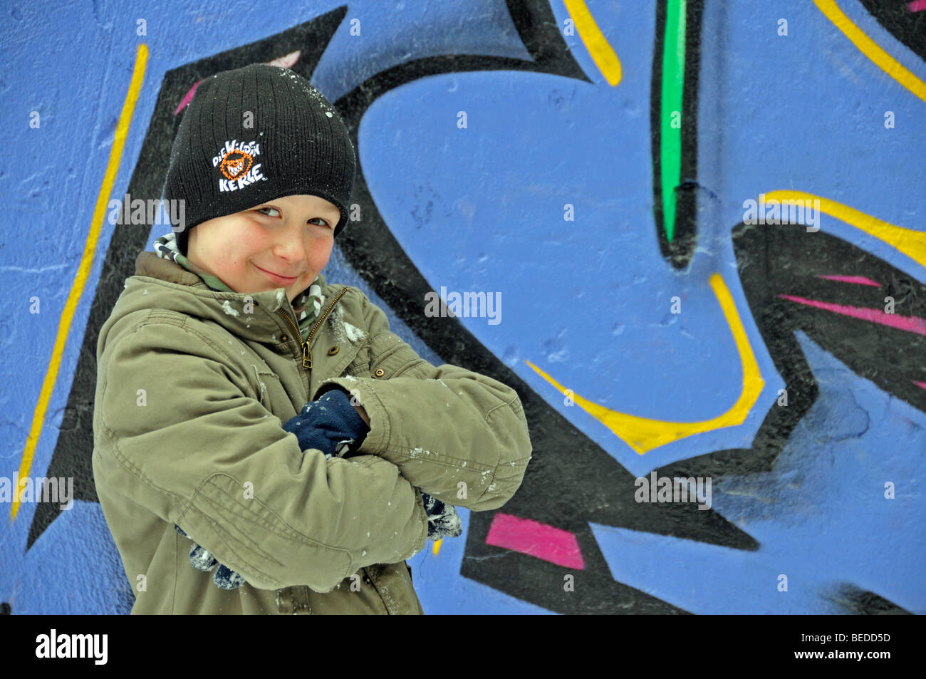 A boy in front of a wall of a football ground sprayed with grafitti, Cologne, North Rhine-Westphalia, Germany, Europe Stock Photo