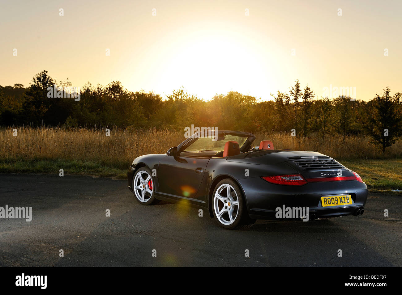 Porsche 997 Cabriolet artistically photographed against the rising sun Stock Photo