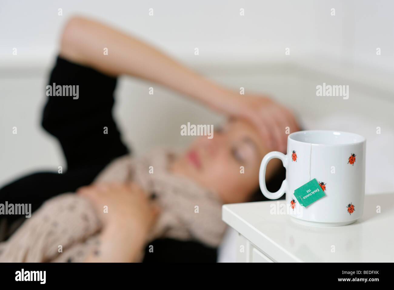 Young woman lying in bed with a cough, cold, flu, ill Stock Photo