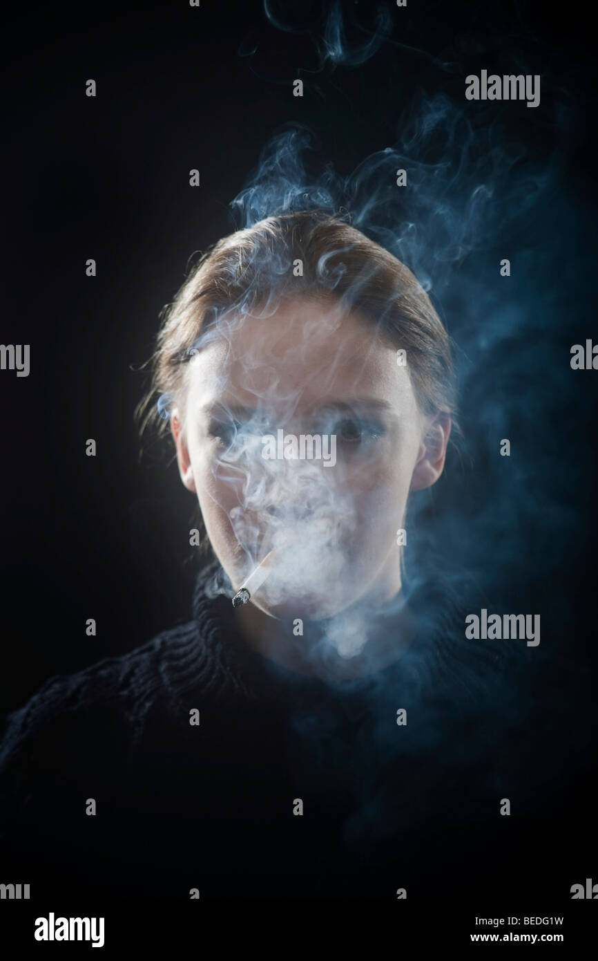 Portrait of a young woman smoking a cigarette, smoke Stock Photo - Alamy