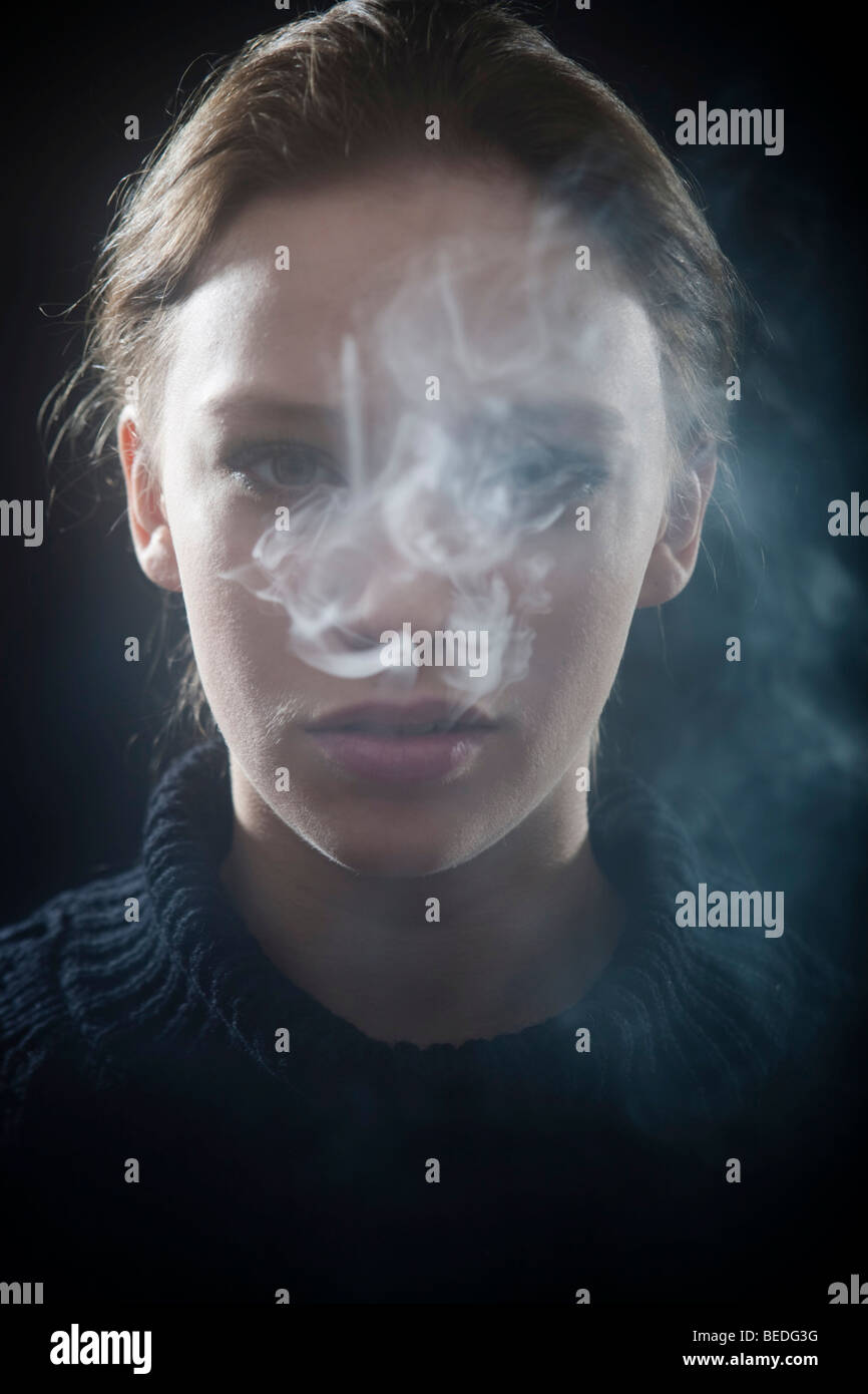 Portrait of a young woman smoking a cigarette, smoke Stock Photo - Alamy