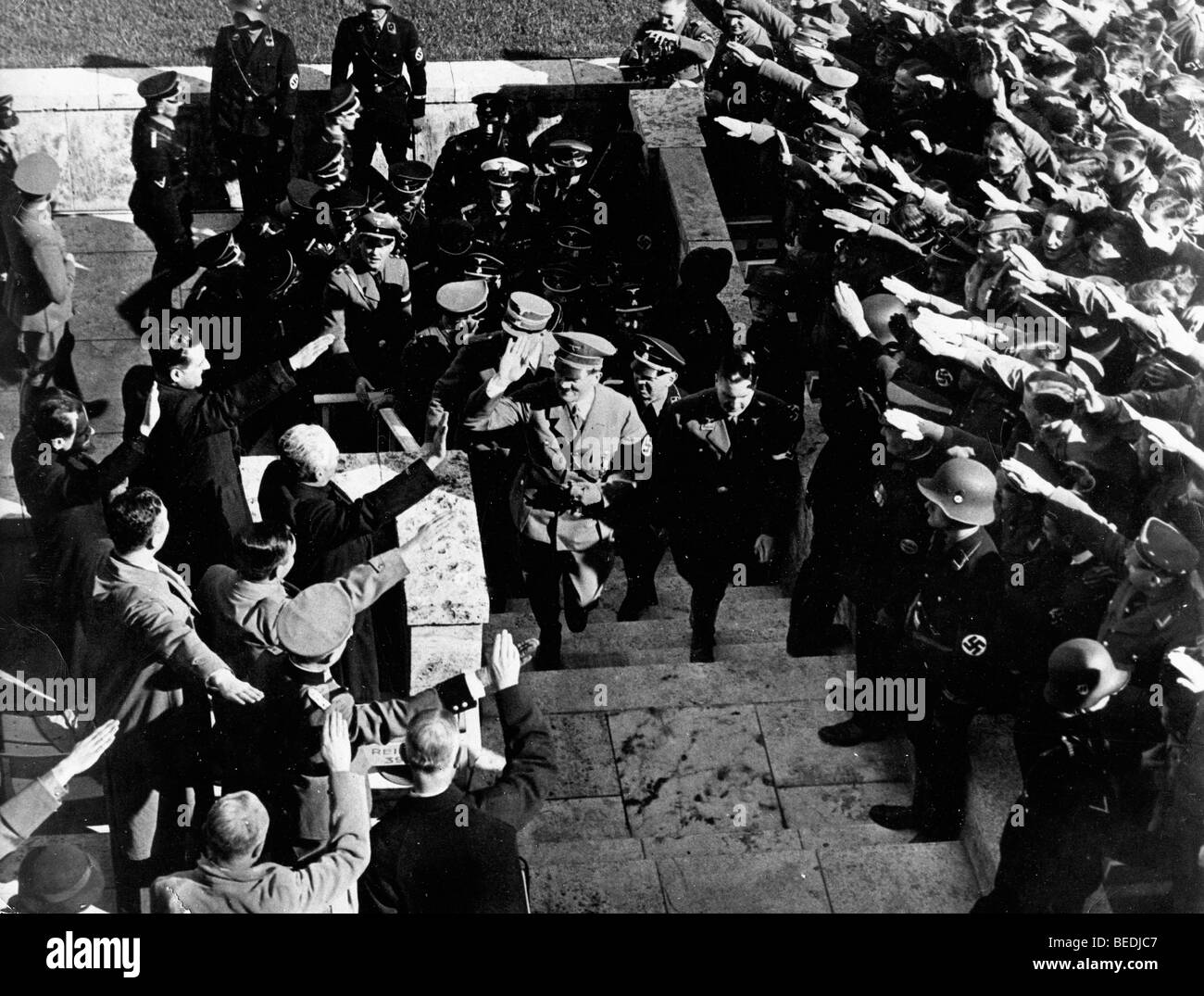 Crowd hailing adolf hitler as he walks up steps Stock Photo